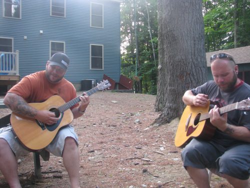 Ran Kime and Wes Kime of brothers KIME playing acoustic guitars at a cabin, capturing stripped-down songwriting and the origins of their sound.