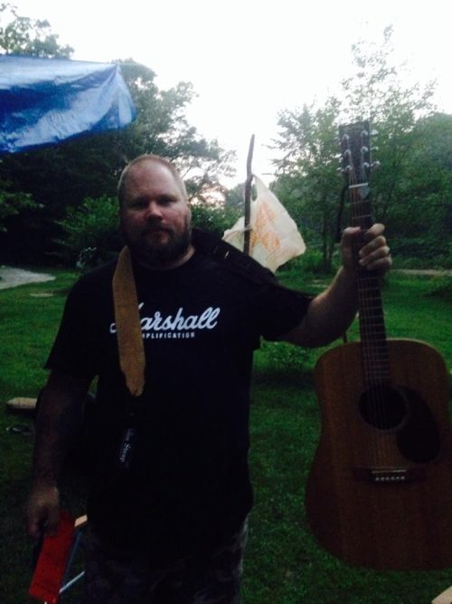 Ran Kime of brothers KIME holding his guitar post-session—an honest snapshot of exhaustion, humor, and life inside independent music.